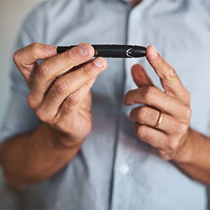 man checking his blood sugar with finger